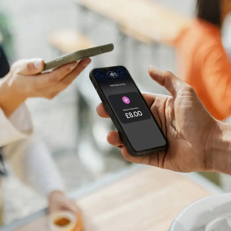 A person using their mobile device to accept a contactless payment from another mobile device